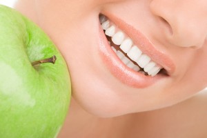 biały uśmiech kobiety i jabłko